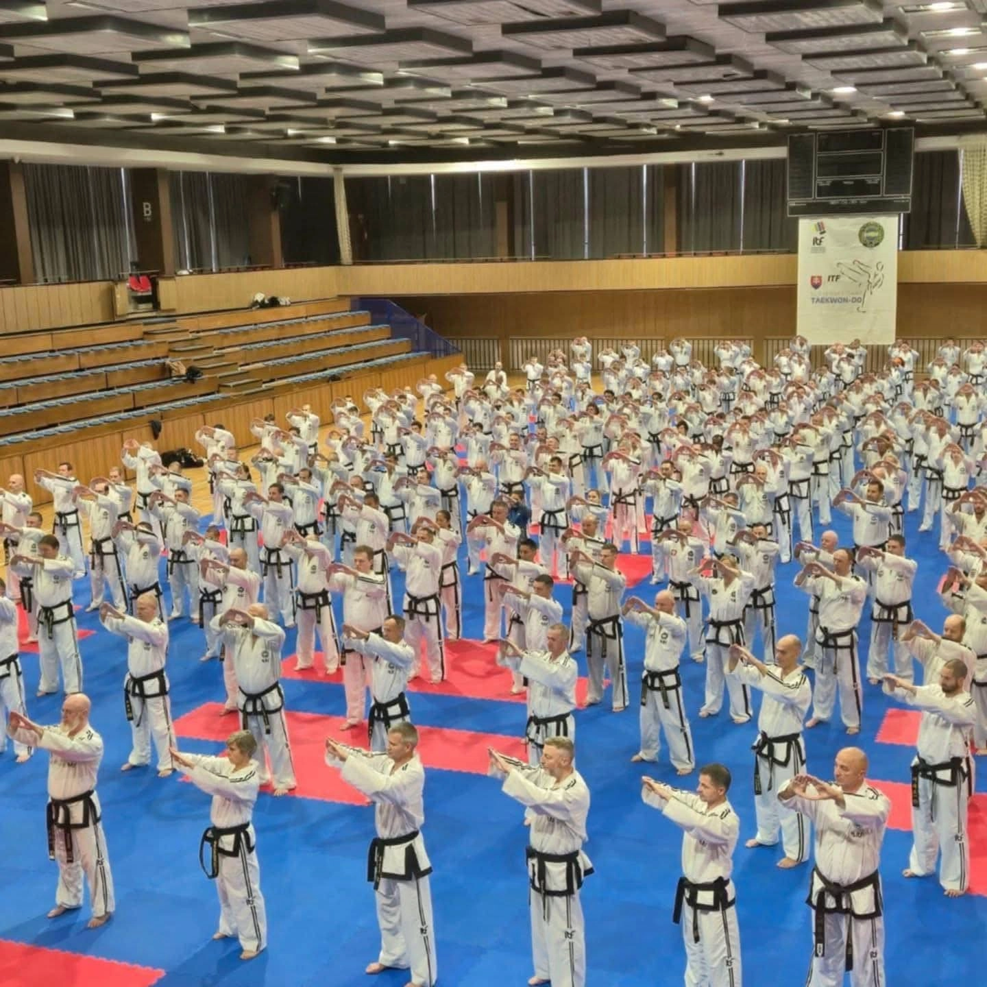 350 participants in Taekwondo uniforms practice techniques at the 189th International Instructor Courses in Trnava, Slovakia.
