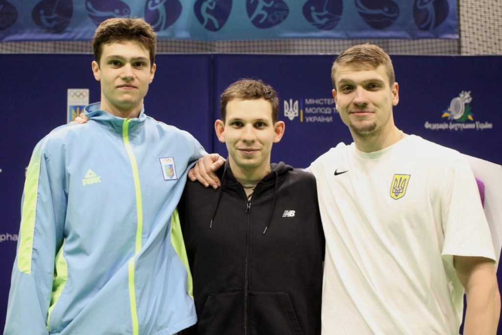 Three young male fencers celebrate podium placements at the Ukrainian Fencing Cup, showcasing national talent and sportsma...
