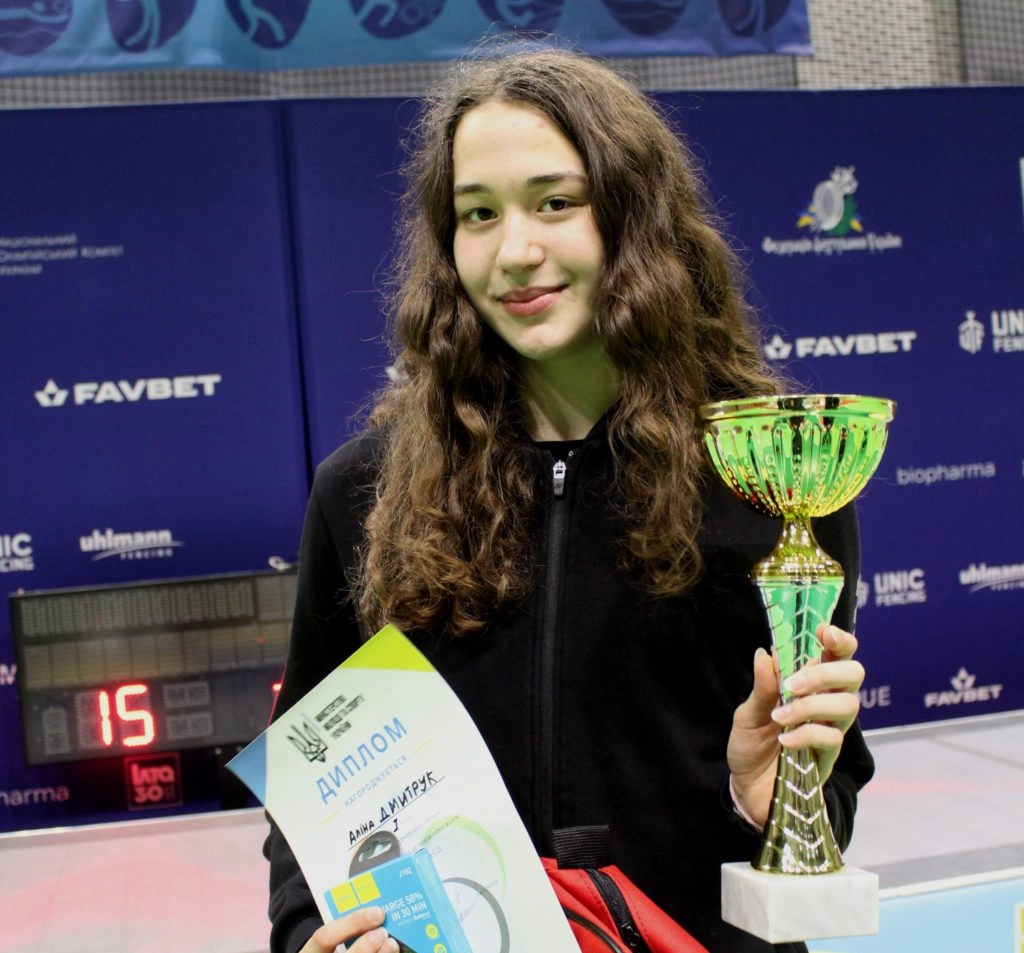 Героїня змагань з фехтування, Аліна Дмитрук, тримає кубок та диплом після перемоги на Турнірі пам