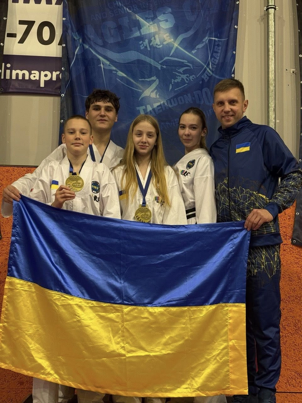 Національна команда України з Таеквон-До на турнірі в Угорщині, отримавши медалі та тримаючи прапор.