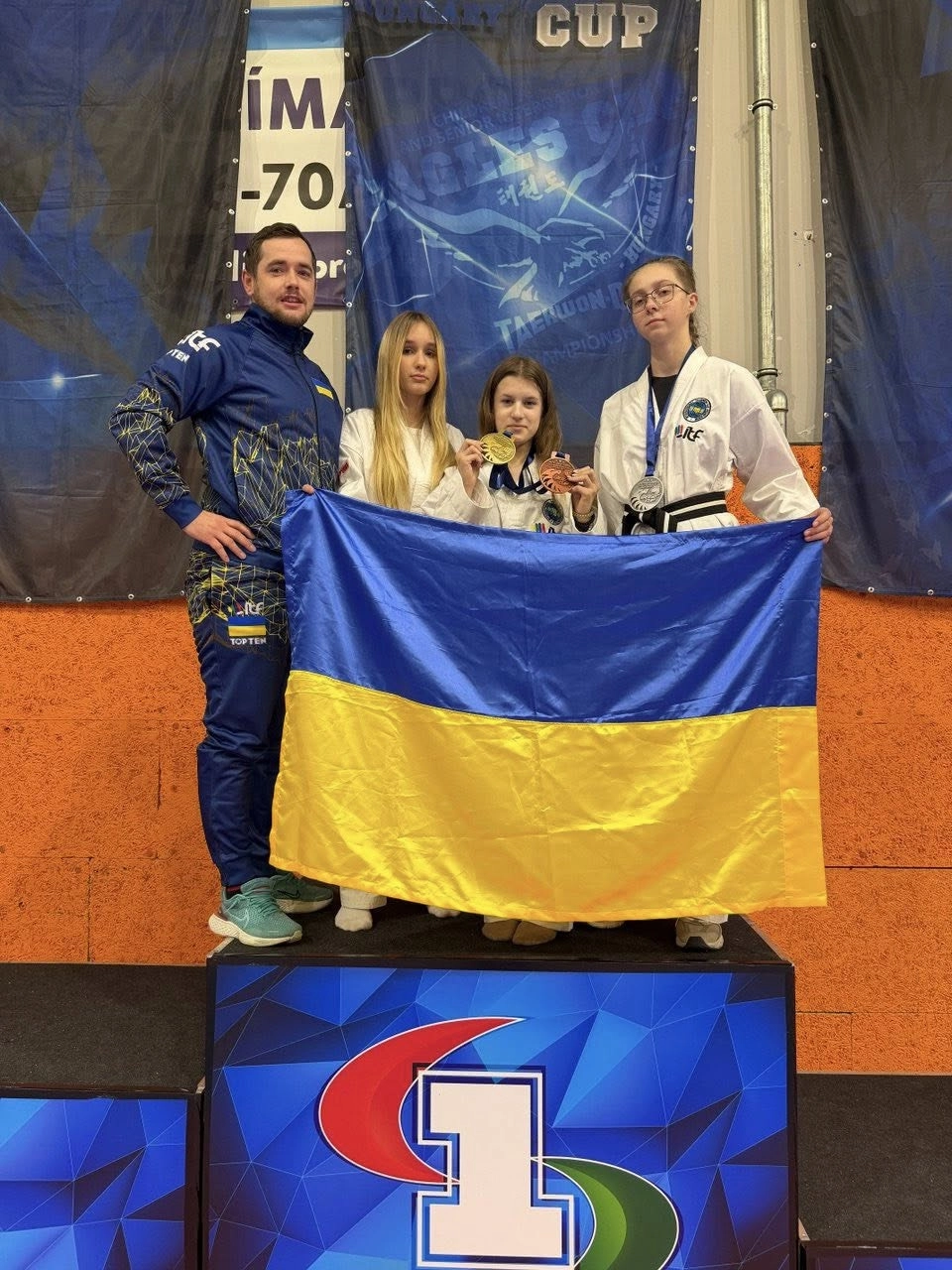 Ukrainian Taekwondo team celebrates success at the XII Mightyfist Open Eagles Cup in Hungary, showcasing their medals.