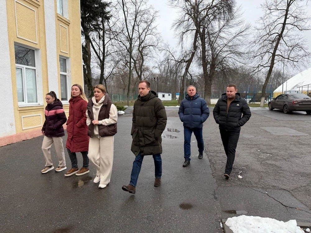 Конференція Асоціації футболу Донецької області з новими рішеннями у тяжких умовах війни, учасники на фоні будинку.