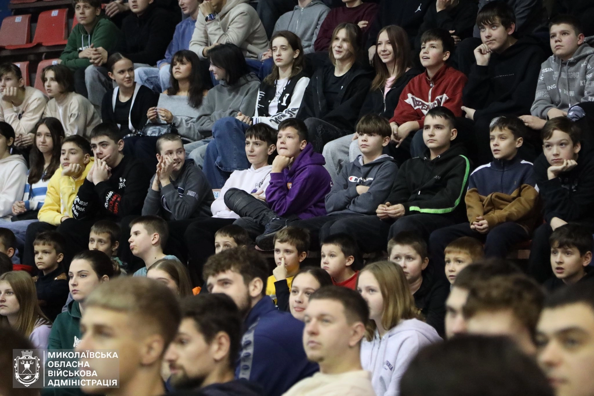 A diverse audience of youth attentively watches the basketball event celebrating achievements in Mykolaiv region