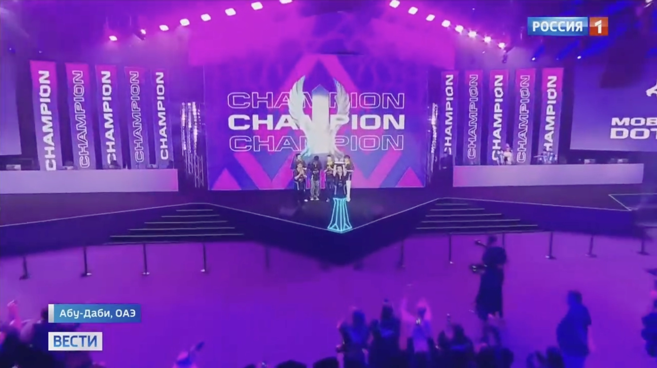 Stage of a Dota 2 tournament showcasing Russian victory, with celebration and a spotlight on the champions in Abu Dhabi.