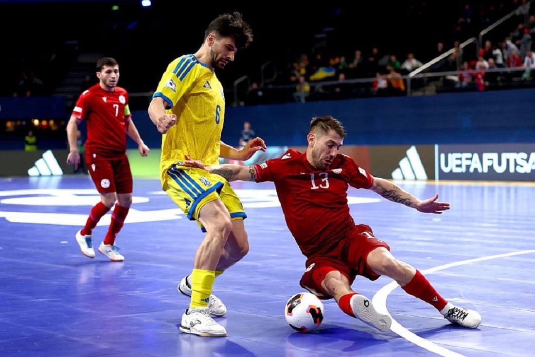 Український гравець у жовтій формі намагається обійти суперника з Вірменії на футзальному майданчику