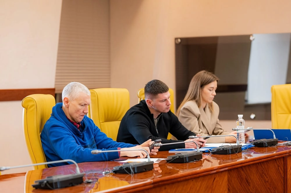 Троє людей за столом на засіданні Комітету масового футболу УАФ, обговорюють робочі питання