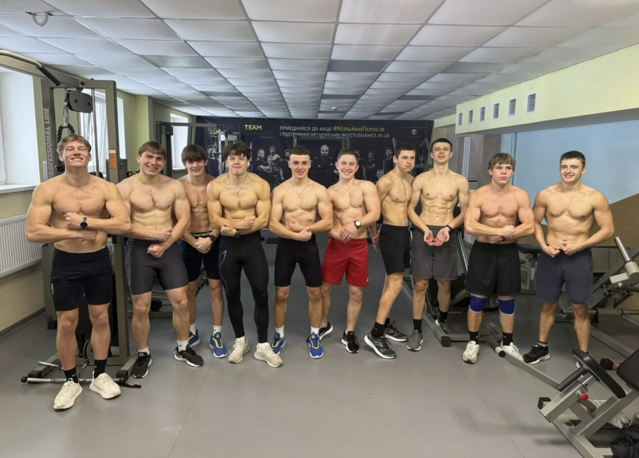 Група молодих спортсменів у спортивному залі під час тренування, готуються до нового сезону веслування