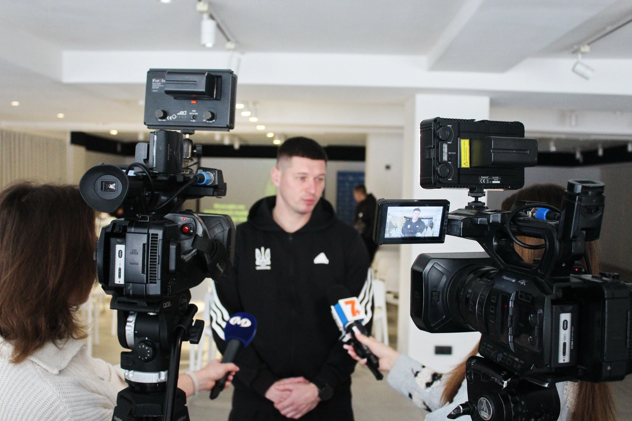 Чоловік у чорному спортивному костюмі дає інтерв'ю журналістам на семінарі УАФ у Хмельницькому