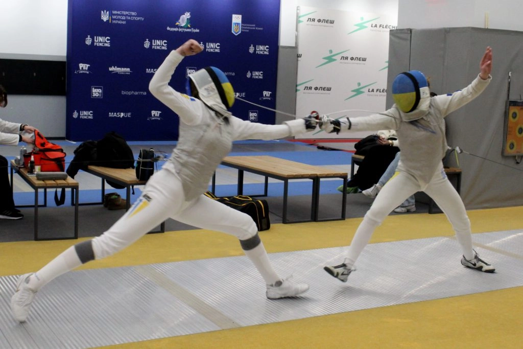 Двоє юніорів у фехтувальних костюмах змагаються на рапірах у клубі «Ля Флєш» під час чемпіонату України