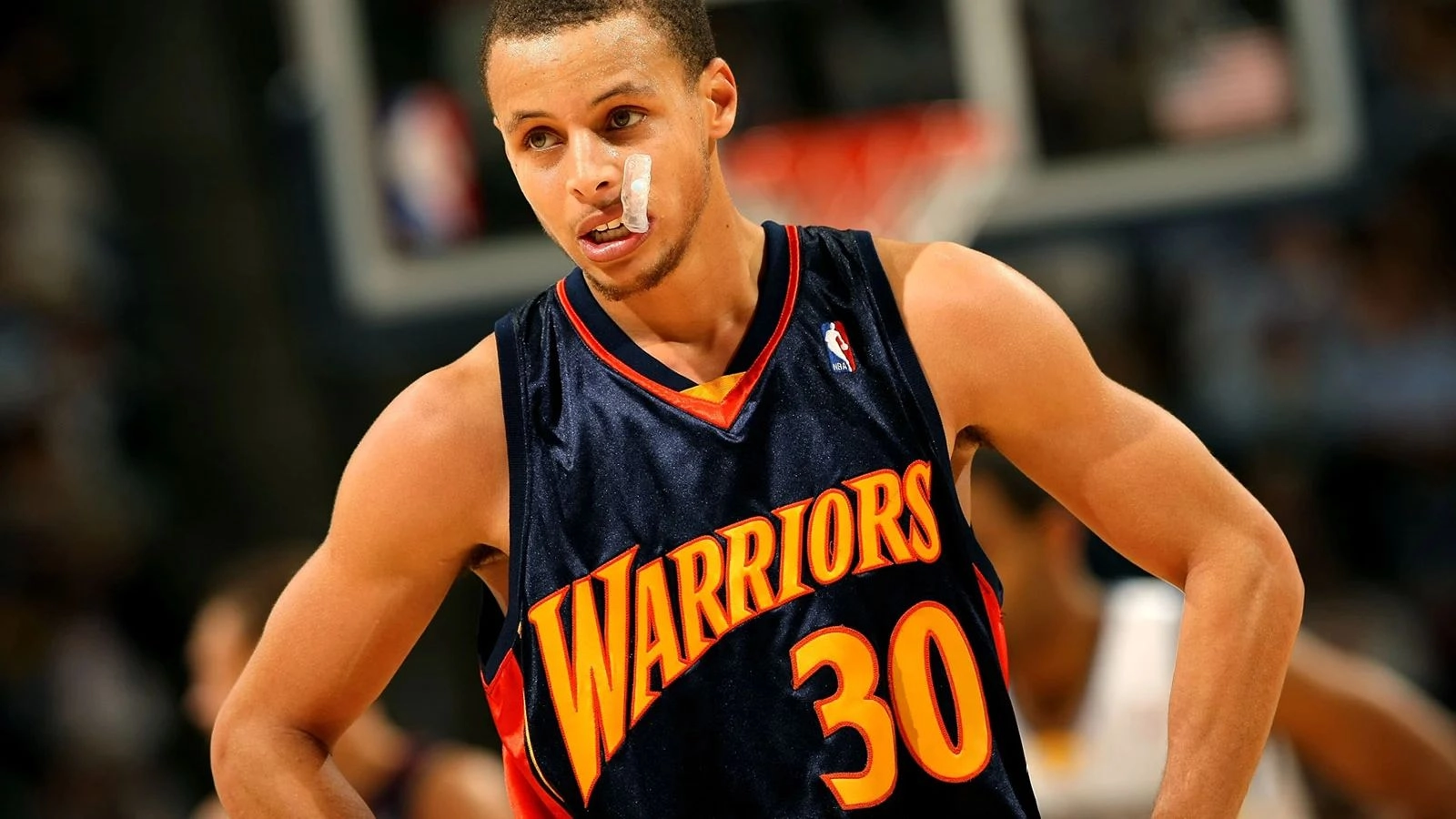 Баскетболіст у формі команди Warriors стоїть на майданчику з пластирем на обличчі