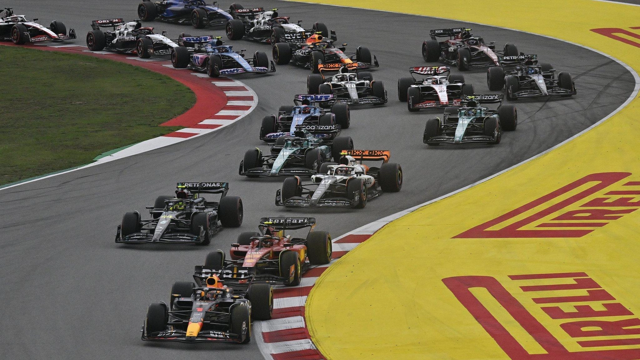 Боліди Формули 1 на трасі Circuit de Catalunya під час гонки, пілоти проходять поворот на високій швидкості