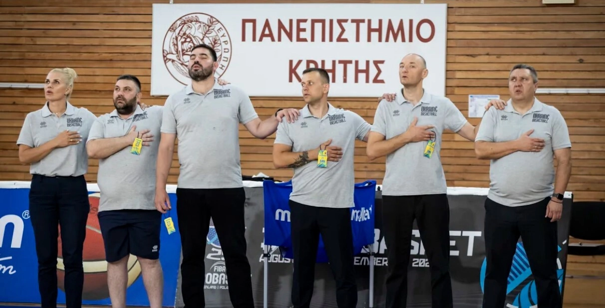 Тренерський штаб чоловічої молодіжної збірної України під час виконання гімну на баскетбольному матчі