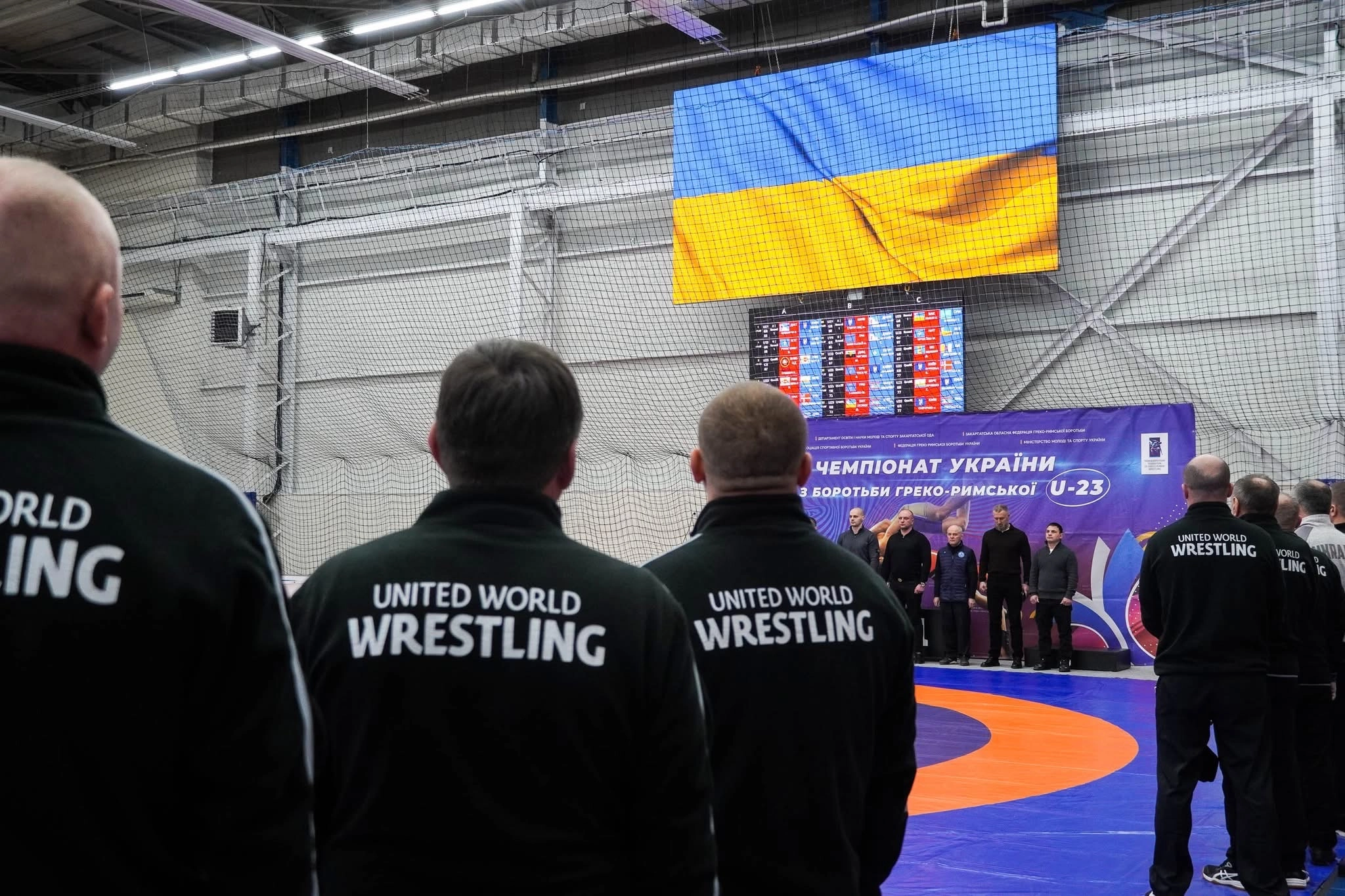 Учасники чемпіонату України з греко-римської боротьби стоять перед прапором України на церемонії відкриття