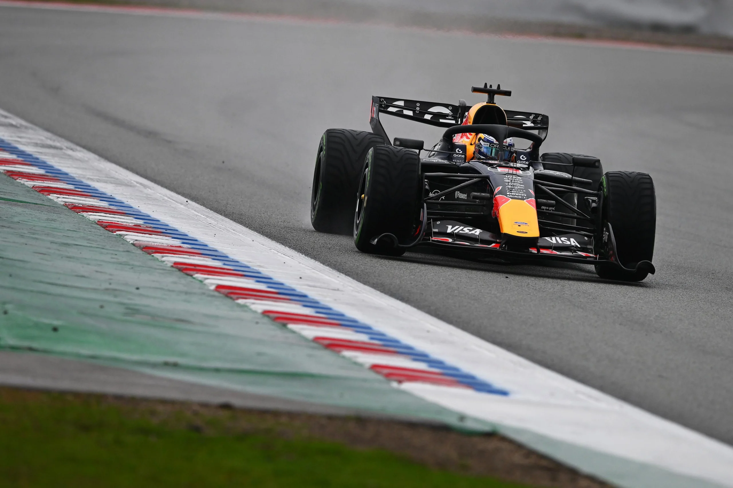 Гоночний болід Red Bull на мокрій трасі під час тестування в Барселоні, пілотований Ісаком Хаджаром