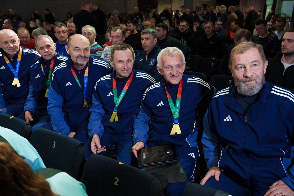 Члени футбольної спільноти в спортивних костюмах сидять на конференції Харківської асоціації футболу