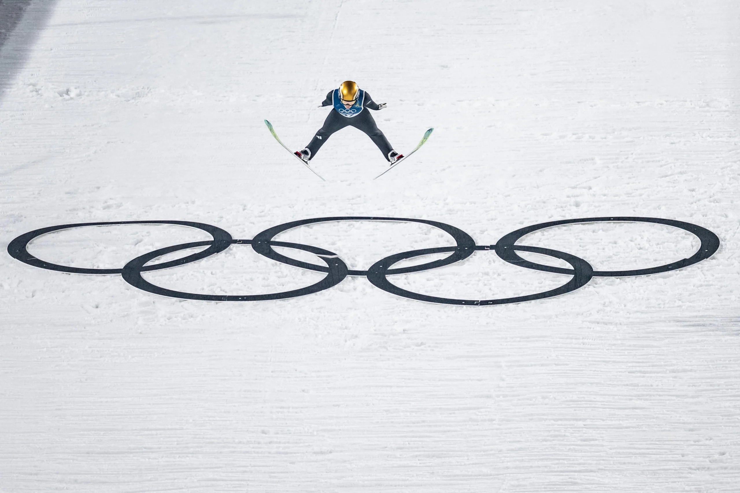 Словенська спортсменка Ніка Превц стрибає над олімпійськими кільцями на змаганнях з лижних стрибків