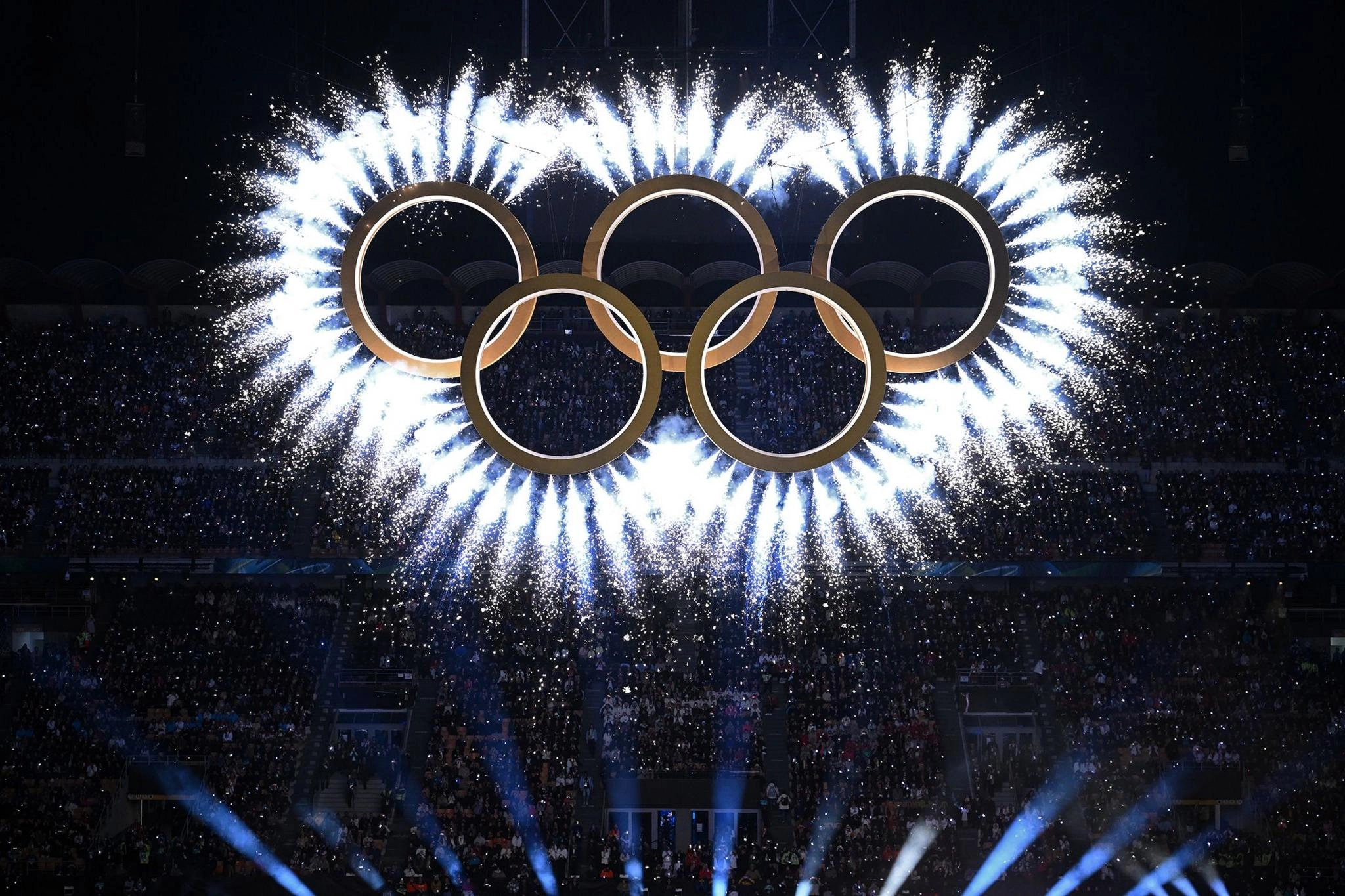 Феєрверки вибухають з олімпійських кілець під час церемонії відкриття на стадіоні Сан-Сіро