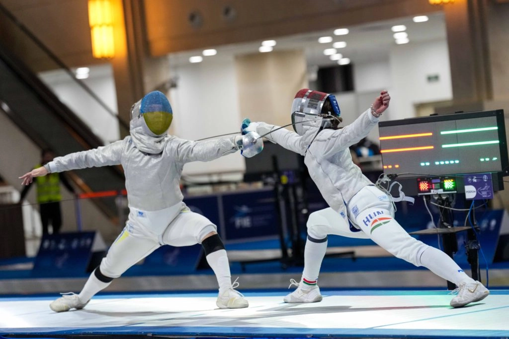 Дві спортсменки у фехтувальних костюмах змагаються на чемпіонаті Європи серед кадетів у Грузії