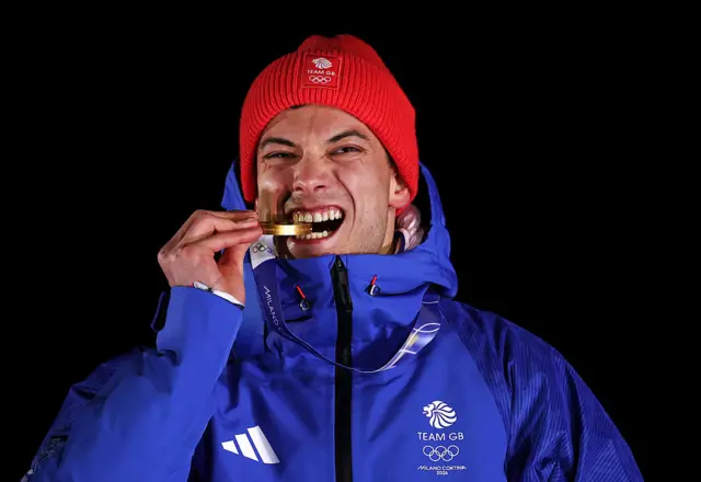 Спортсмен команди Великобританії кусає золоту медаль на Олімпійських іграх у Мілан-Кортіна 2026
