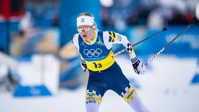 Шведська лижниця в жовто-синій формі змагається на Олімпійських іграх у крос-кантрі на 50 км