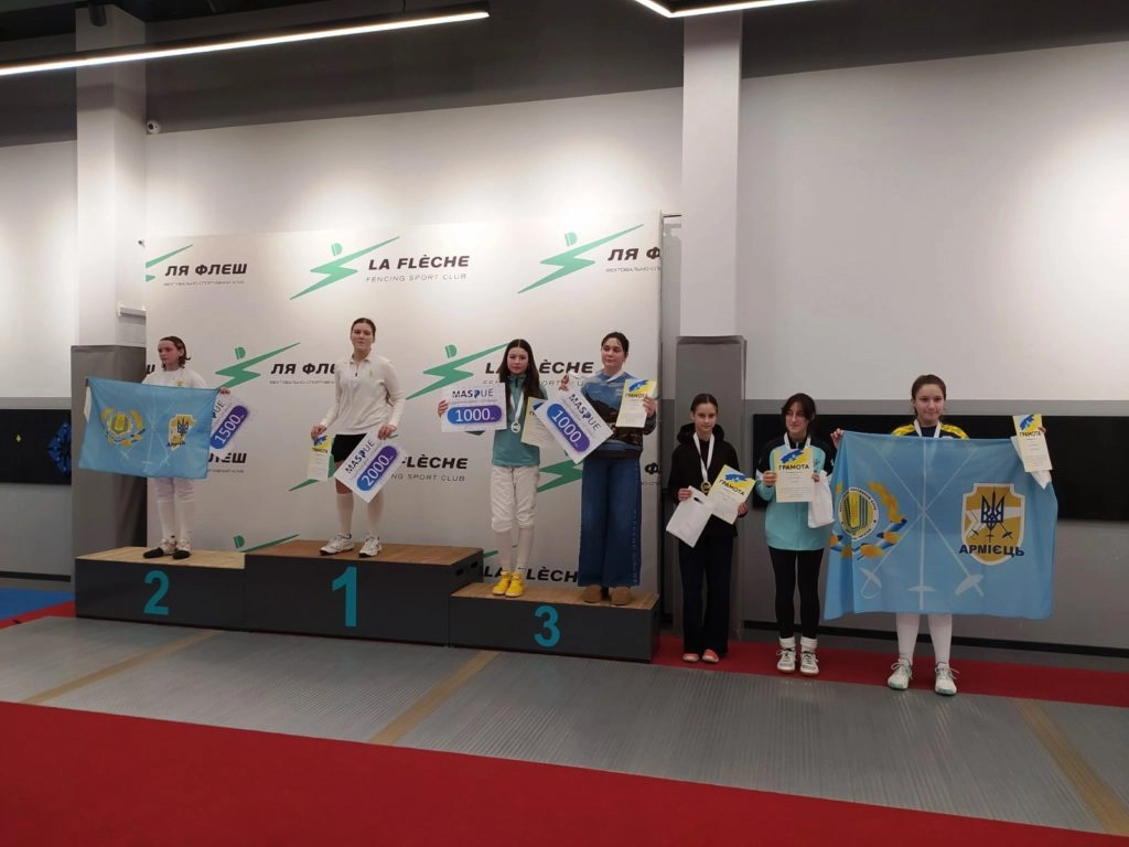 Переможці змагань з фехтування на рапірах на п'єдесталі пошани з медалями та прапорами клубів