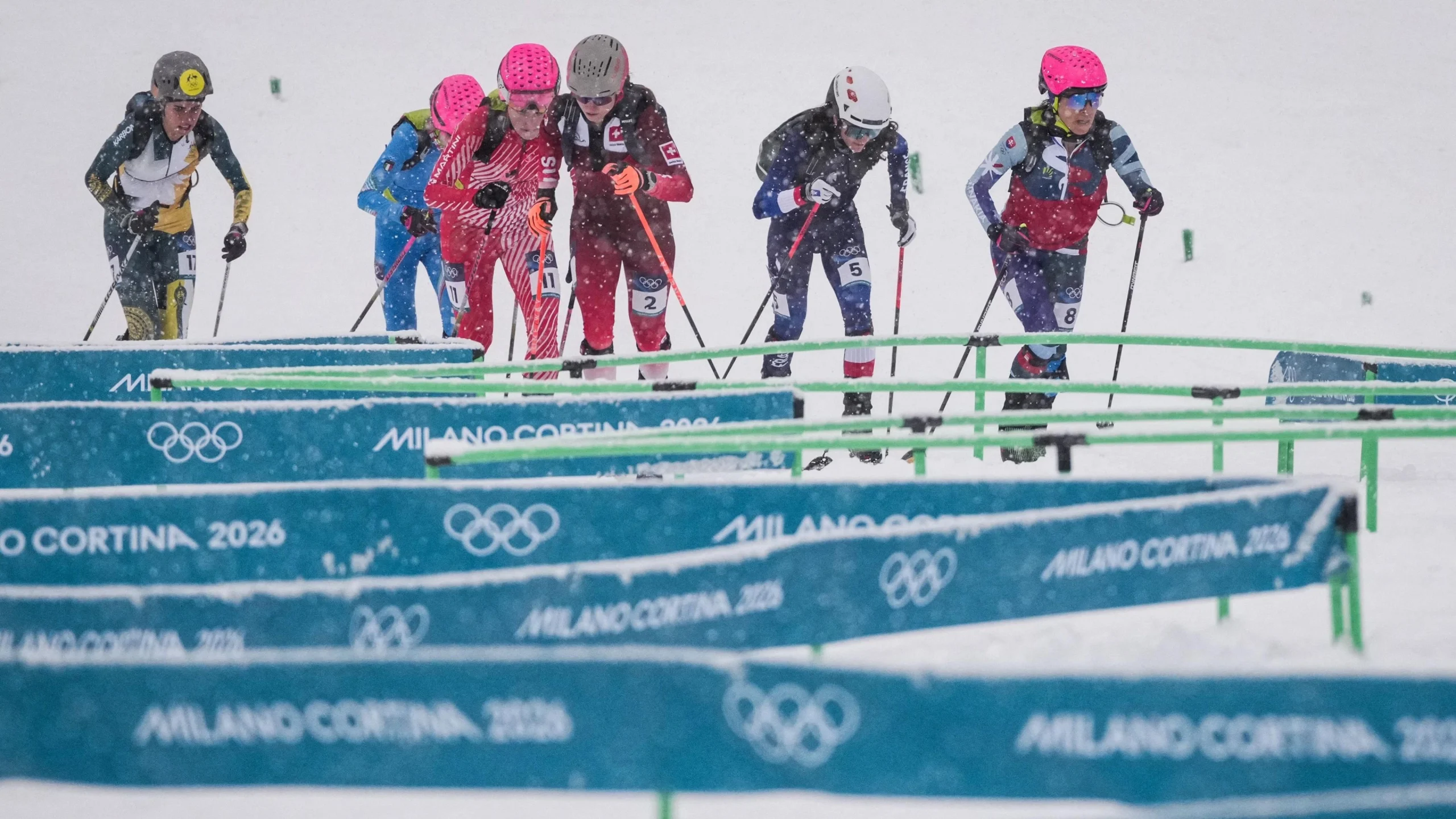 Спортсмени змагаються у спринті на лижах під час зимової Олімпіади в умовах снігопаду