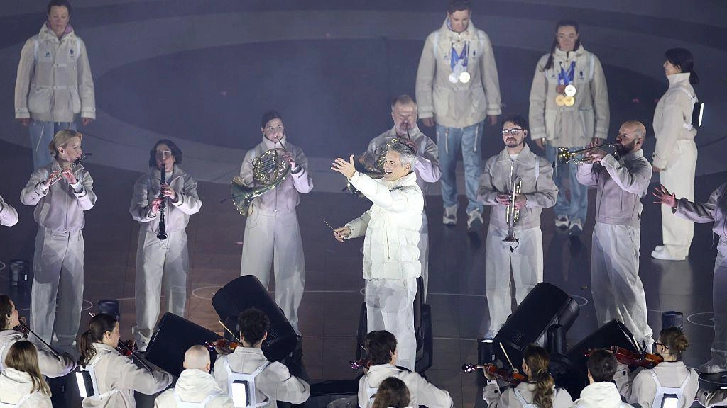 Музиканти у білих костюмах виступають на сцені під час церемонії закриття Олімпіади в Вероні