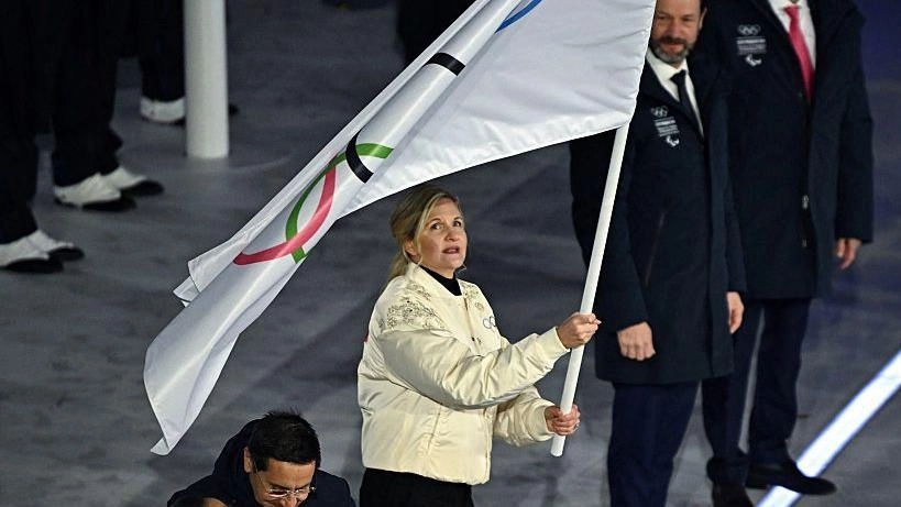 Жінка тримає олімпійський прапор під час церемонії закриття на Олімпійській арені у Вероні