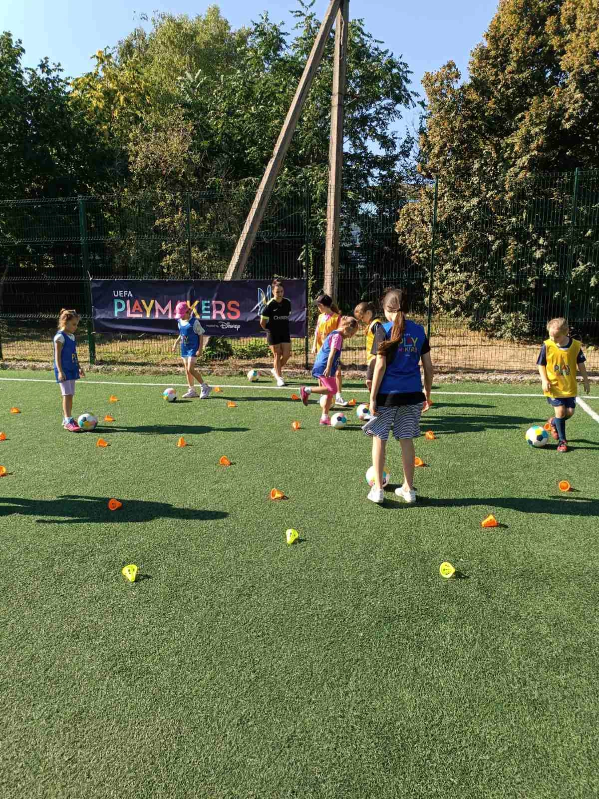 Діти грають у футбол на зеленому полі під час тренування UEFA Playmakers у Кропивницькому
