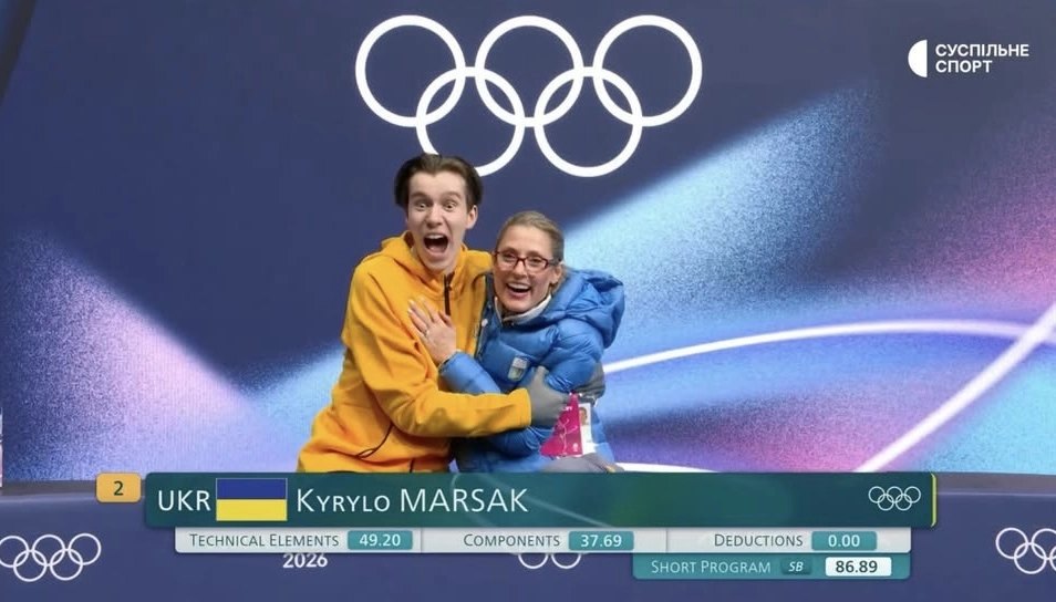 Український фігурист Кирило Марсак радіє з тренером після успішного виступу на Олімпіаді в Мілані
