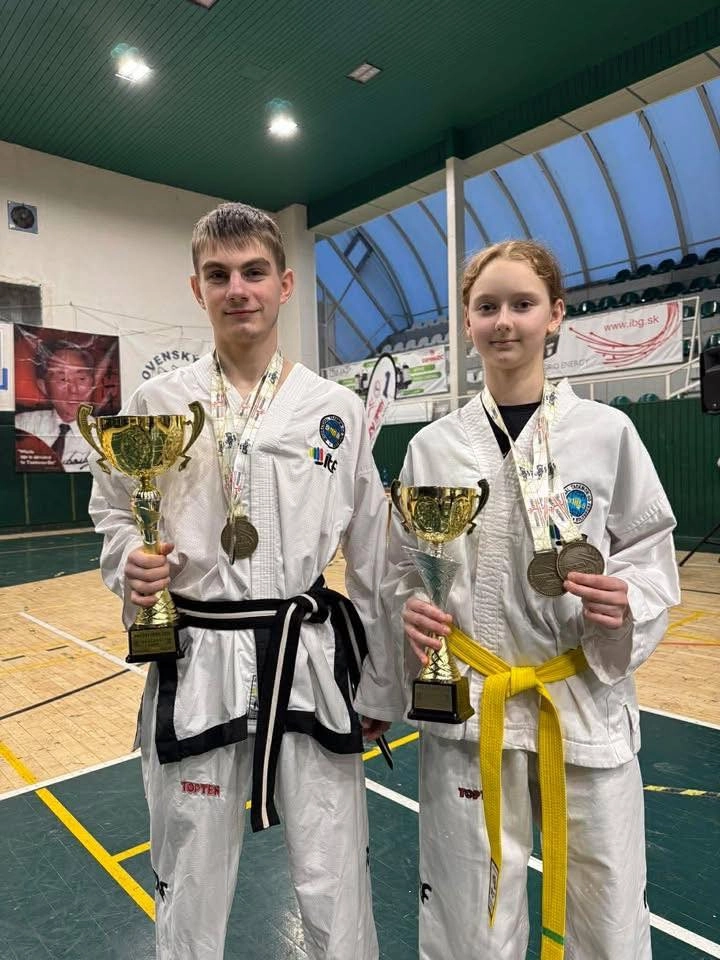 Двоє молодих спортсменів у кімоно з медалями та кубками на турнірі Presov Open у Словаччині