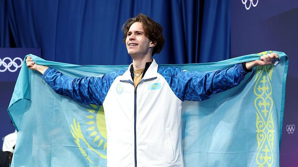 Спортсмен з Казахстану тримає національний прапор після перемоги на Олімпійських іграх у фігурному катанні