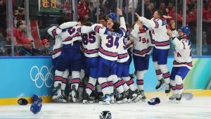 Хокеїсти збірної США святкують перемогу над Канадою у фіналі Олімпіади-2026, обіймаючи один одного на льоду