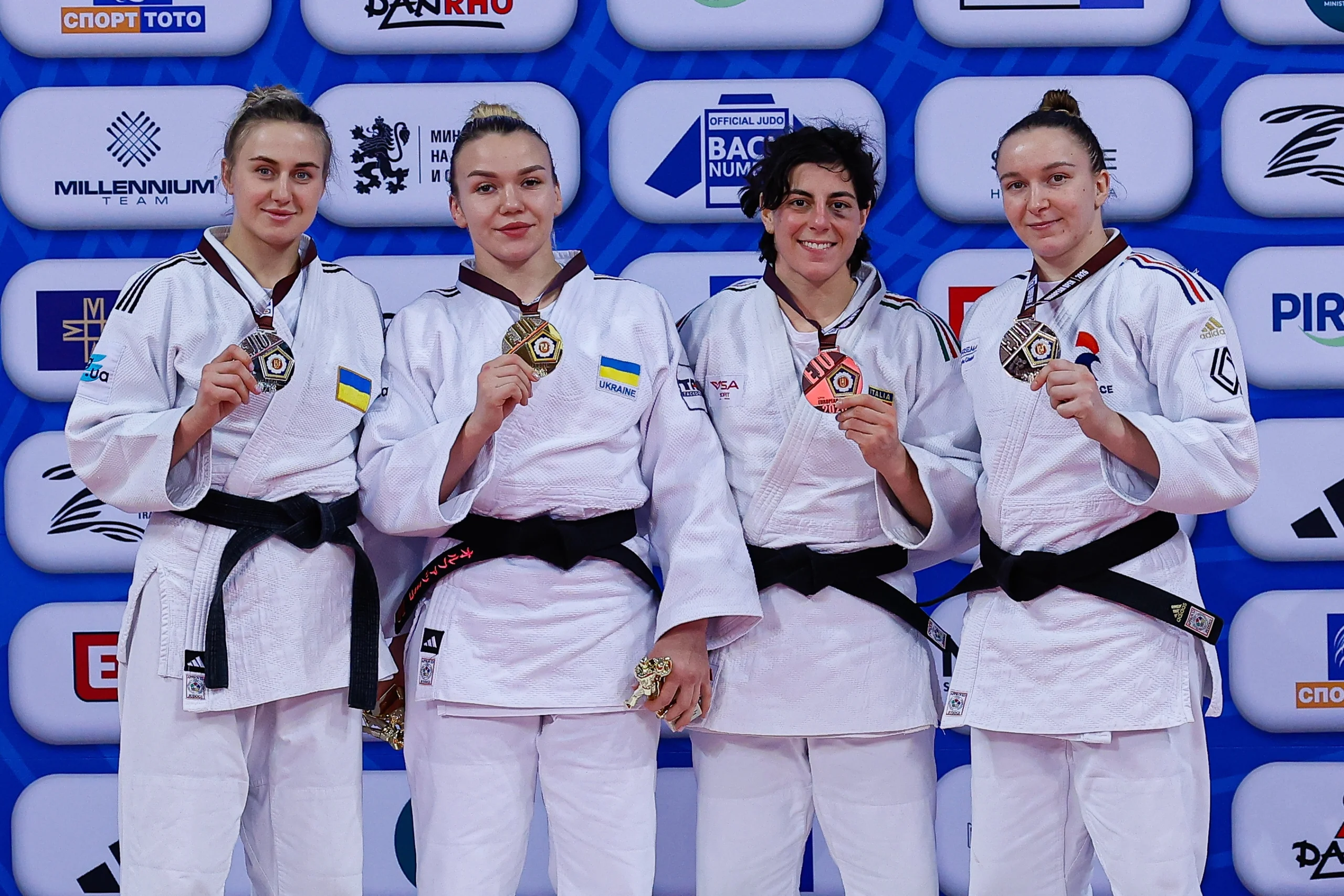 Чотири спортсменки в кімоно з медалями на п'єдесталі пошани після змагань з дзюдо в Софії