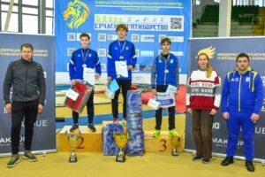 Переможці Зимового Чемпіонату України U19 на п'єдесталі з медалями та кубками, тренери поруч