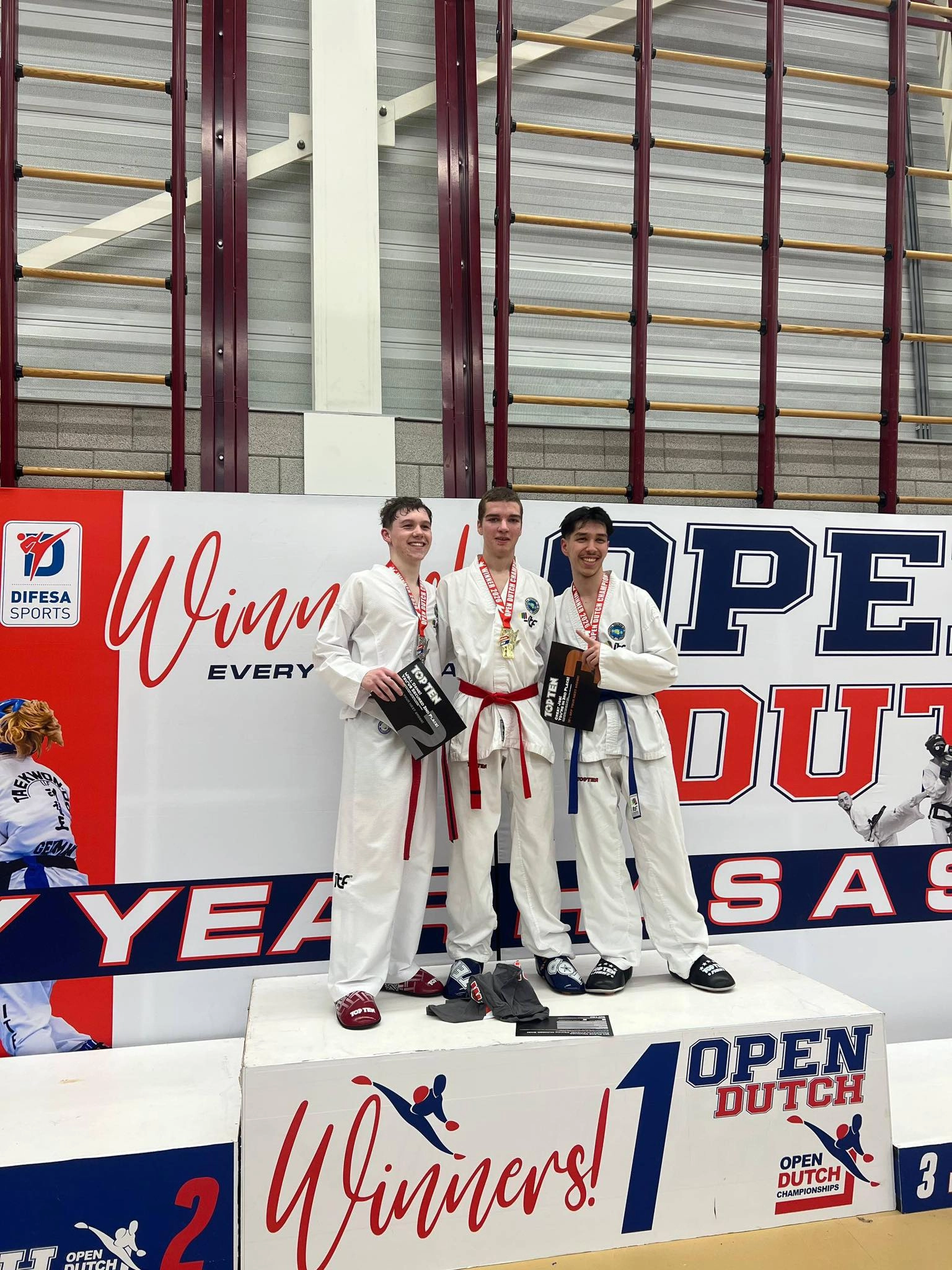 Троє спортсменів у кімоно стоять на п'єдесталі переможців Open Dutch Championship 2026