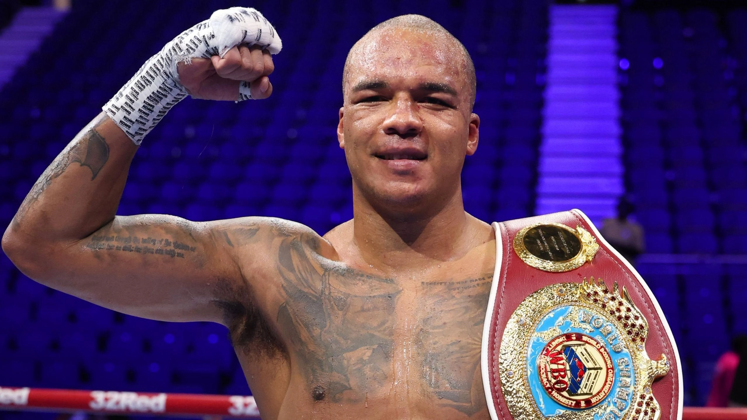 Боксер з піднятою рукою та чемпіонським поясом на арені після перемоги в бою