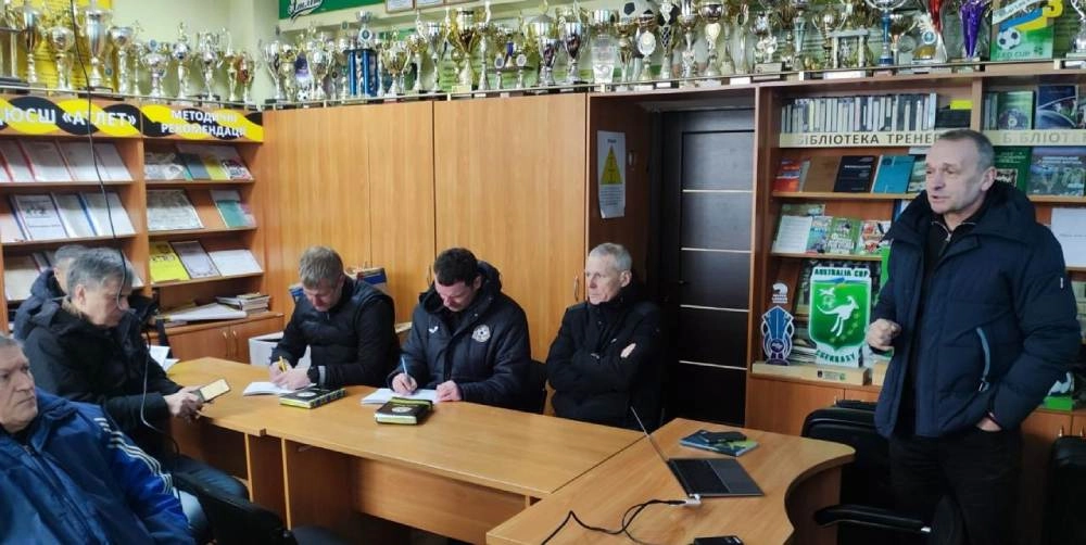 Тренери на семінарі в ДЮСШ «Карпати» (Львів) обговорюють зміни до Правил гри, сидячи за столом