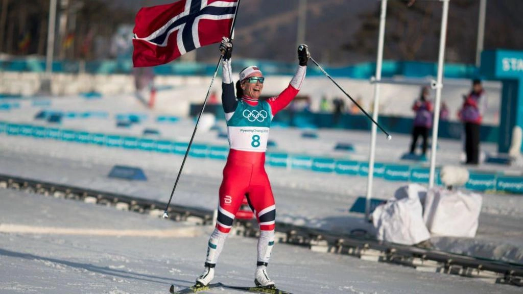 Лижниця з норвезьким прапором святкує перемогу на зимових Олімпійських іграх