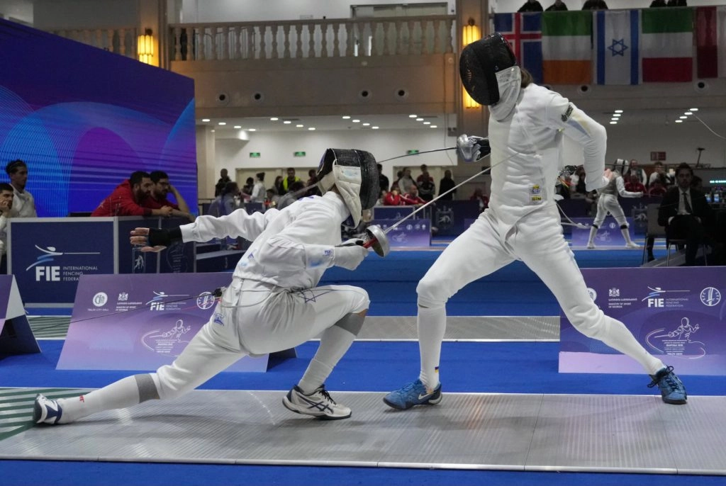 Двоє фехтувальників у білих костюмах змагаються на чемпіонаті Європи у Тбілісі