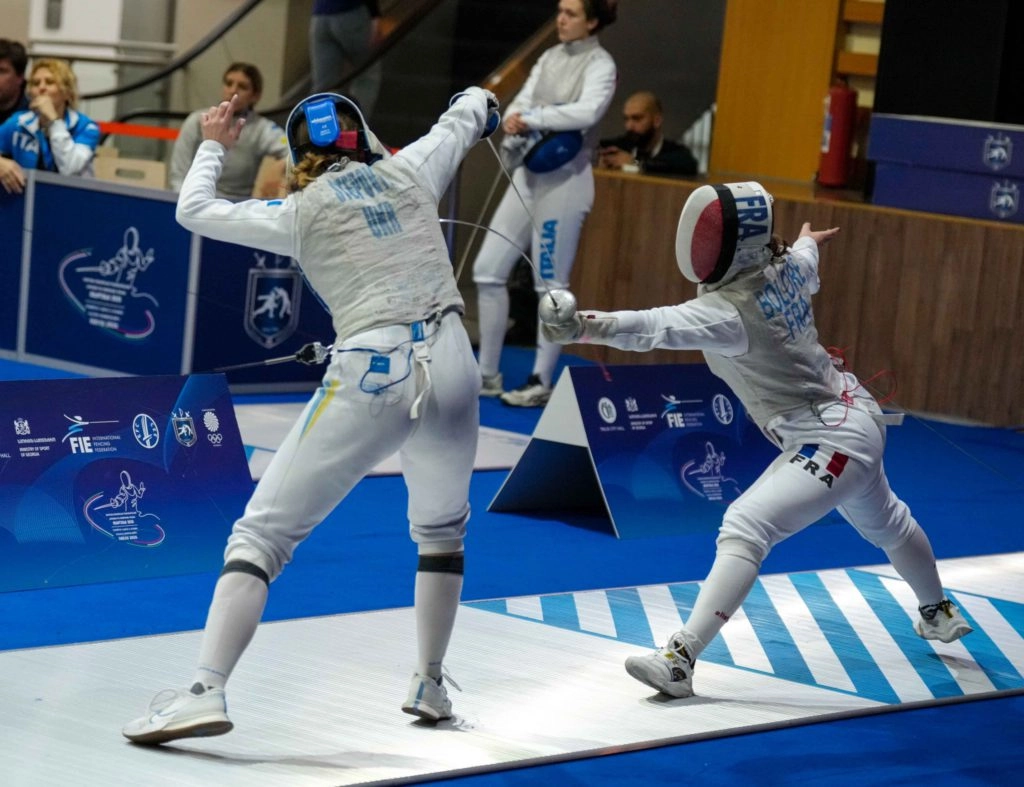 Дві фехтувальниці у поєдинку на чемпіонаті Європи, одна з них атакує суперницю шпаги