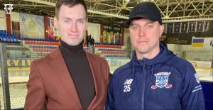 Двоє чоловіків у спортивній арені, один у піджаку, інший у спортивній куртці з емблемою клубу
