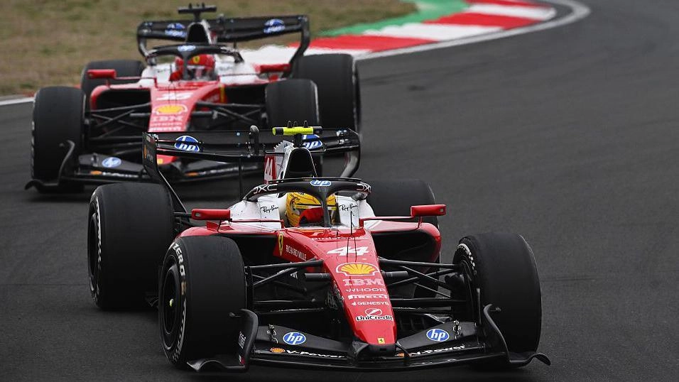 Два боліди Ferrari на трасі під час гонки Формули 1, один з яких веде Льюїс Хемілтон