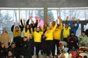 Група вболівальників у жовтих футболках радісно піднімає руки на трибунах арени Макс Айхер