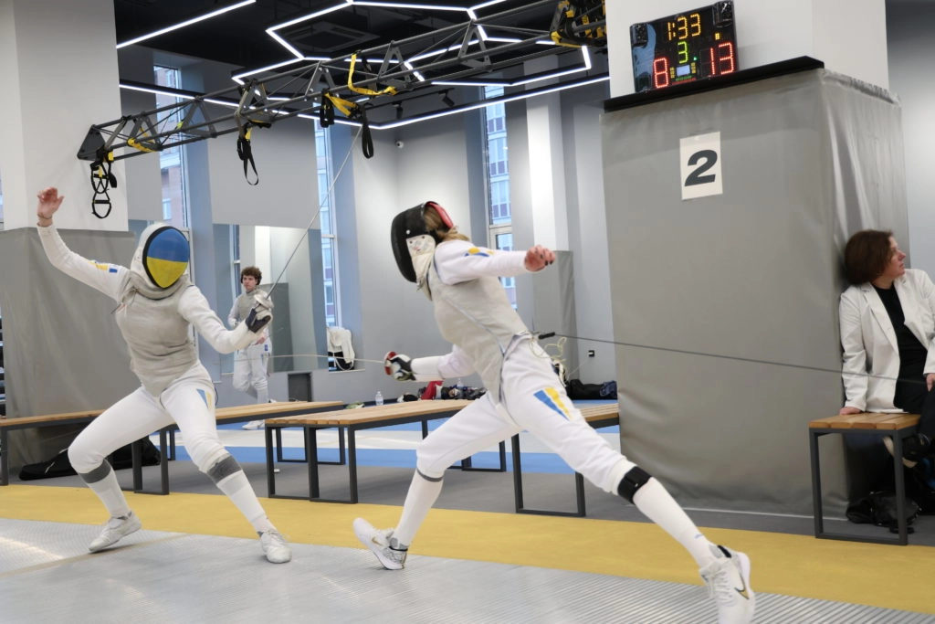 Дві фехтувальниці в білому екіпіруванні змагаються на чемпіонаті України серед молоді U-23