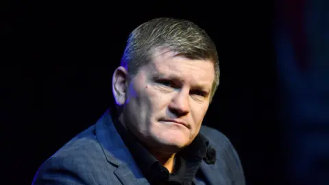 Колишній боксер Ріккі Хаттон сидить у темному піджаку, дивлячись у бік камери