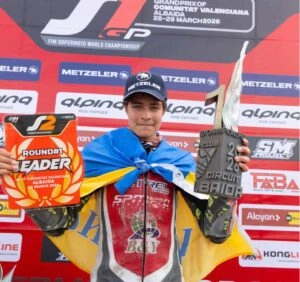Євсевій Ковальов з українським прапором тримає трофей і табличку лідера на подіумі в Альбайді