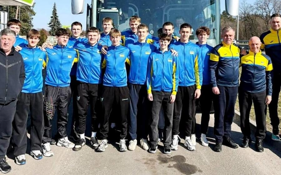 Юнацька збірна України U-18 з волейболу позує перед автобусом у спортивній формі перед матчами в Сігулді