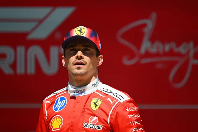 Пілот Ferrari в червоному комбінезоні на фоні логотипу Шанхай під час гоночного уїк-енду
