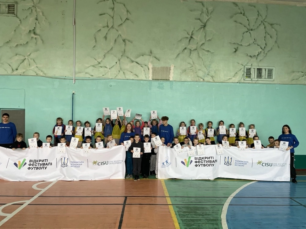 Діти та молодіжні лідери з сертифікатами на футбольному заході в спортивному залі